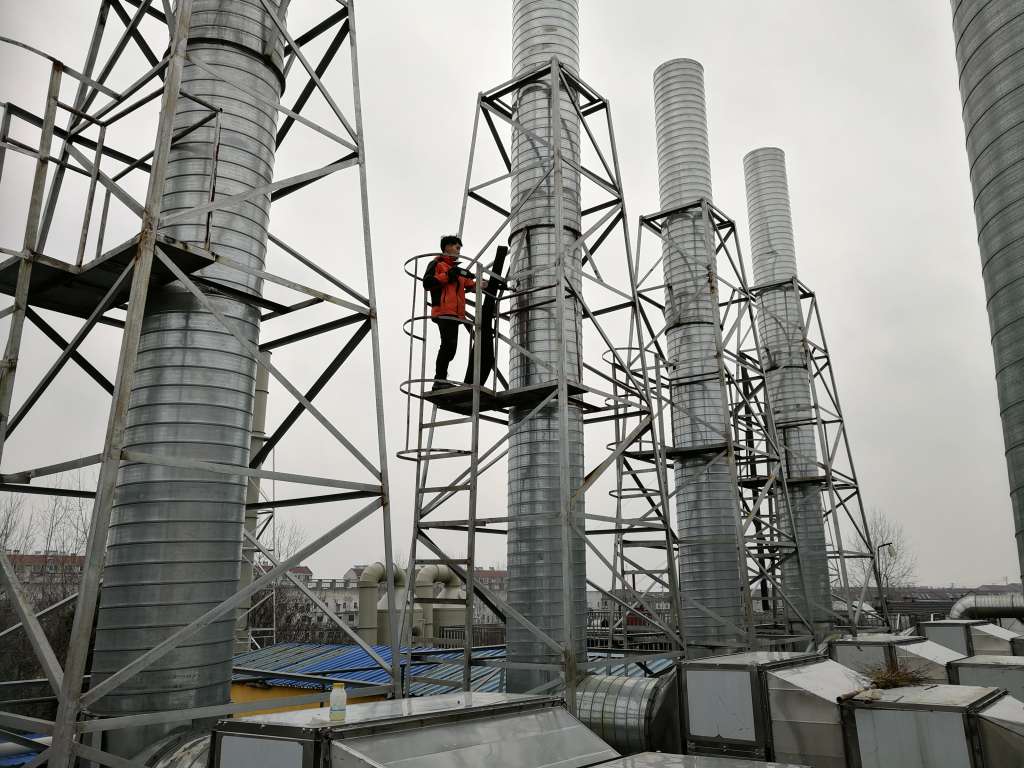 工作服,拎着装满采样工具的箱子,一名采样员爬上5米左右高的采样平台